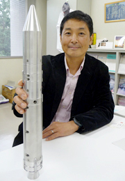 Professor Morita with a miniature of the Epsilon launch vehicle