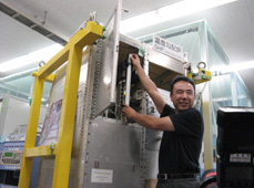 Astronaut Furukawa taking out a test-material cartridge from the temperature-gradient furnace, while conducting a Hicari experiment during training at the Tsukuba Space Center.