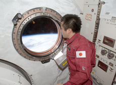 Astronaut Koichi Wakata looking at Earth through the window of Kibo (Courtesy of NASA)