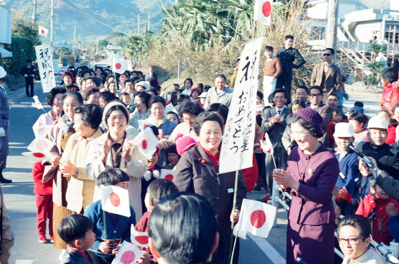 Residents of the Ohsumi peninsula line up with congratulatory flags upon the launch of Ohsumi