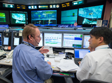 Astronauts Michael Fincke and Onishi at the CAPCOM console (courtesy: JAXA/NASA)