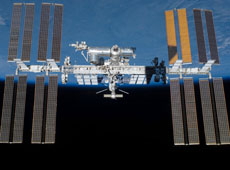 Image of the International Space Station with a backdrop showing the dramatic contrast between blue earth and black space (courtesy: NASA)