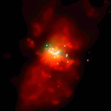 Galaxy M82 observed in X-rays. There is a black hole at its center. Blue, green and red indicate levels of energy of X-rays, from high to low. (courtesy: NASA/SAO/G.Fabbiano et al.)