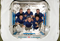 The Experiment Logistics Module - Pressurized Section (ELM-PS) of Kibo in orbit. Astronaut Takao Doi (bottom right) and other crewmembers of the STS-123. (Courtesy of NASA)